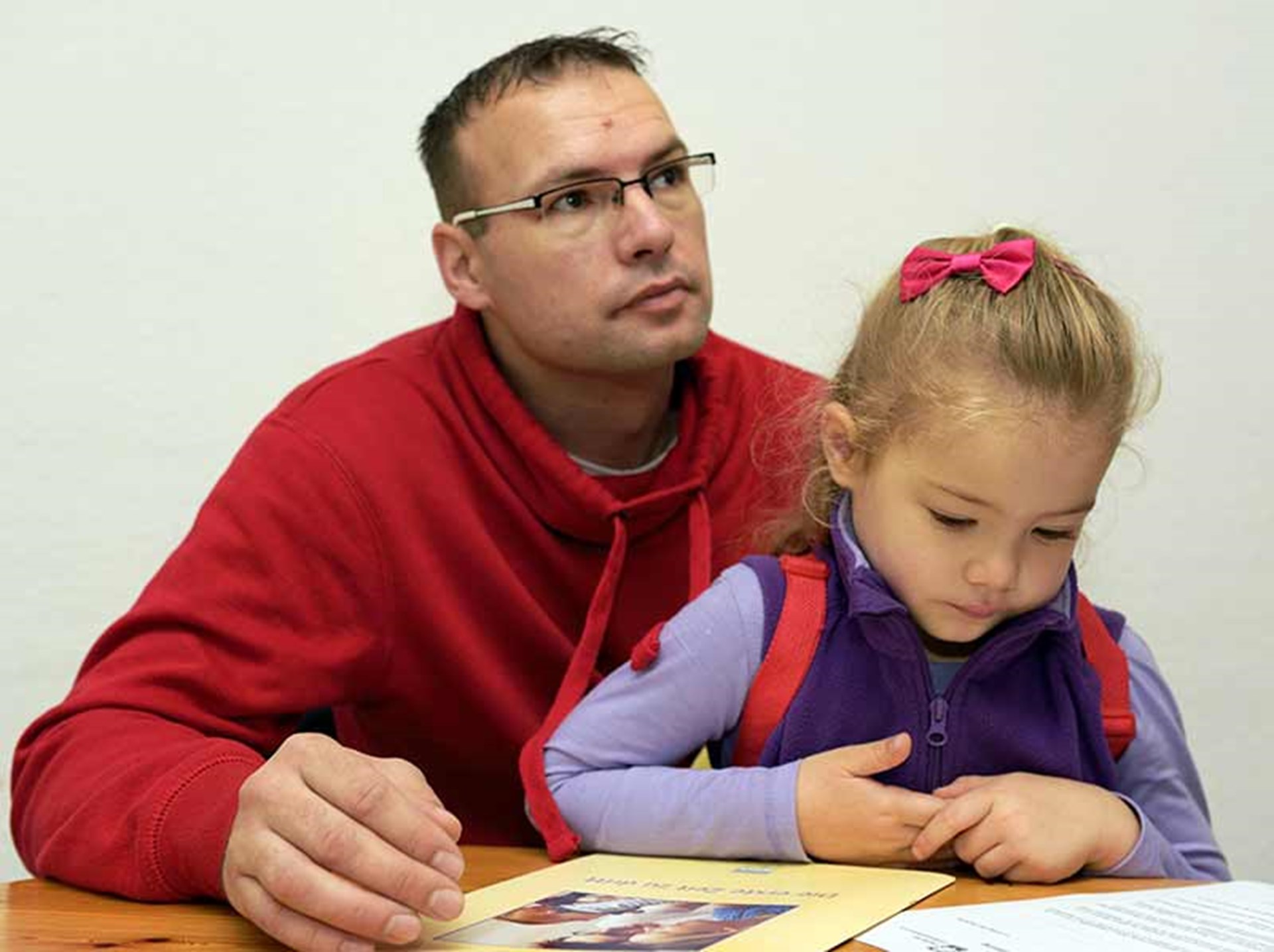Vater sitzt mit Tochter am Tisch